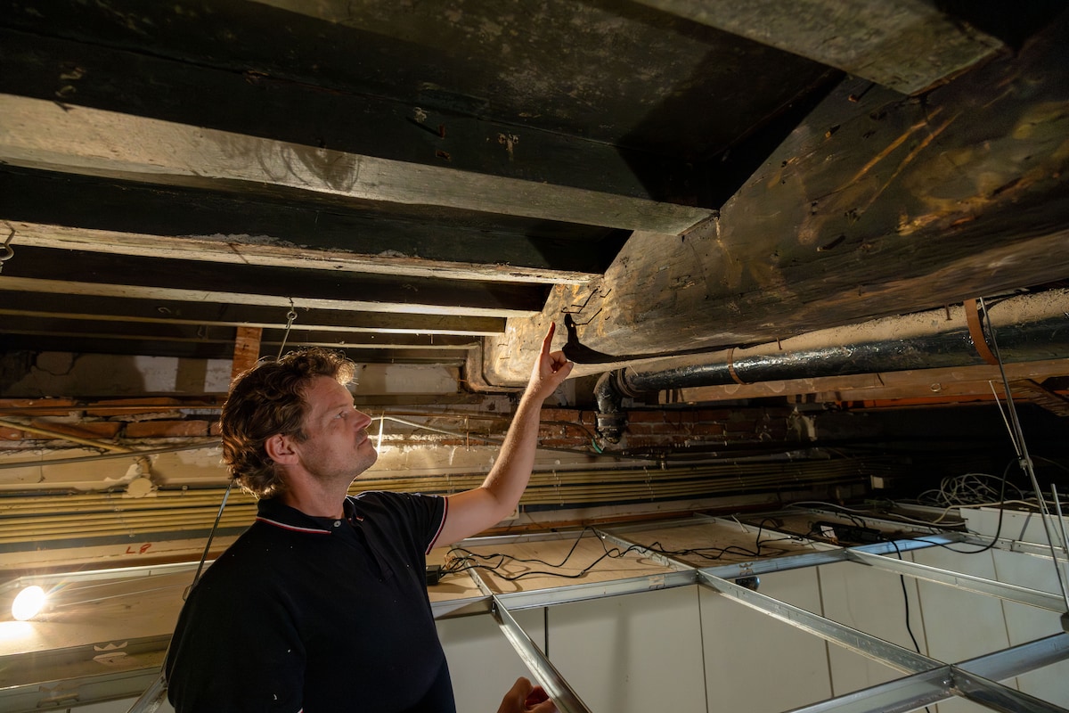 Bouwhistoricus Geert Jan van der Schee bij een van de balkschilderingen.
