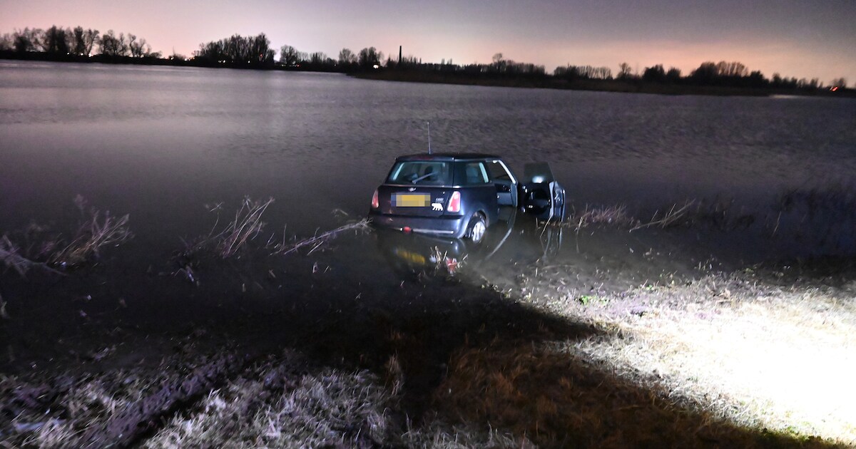 Auto rijdt van dijk af het water in bij Ooij