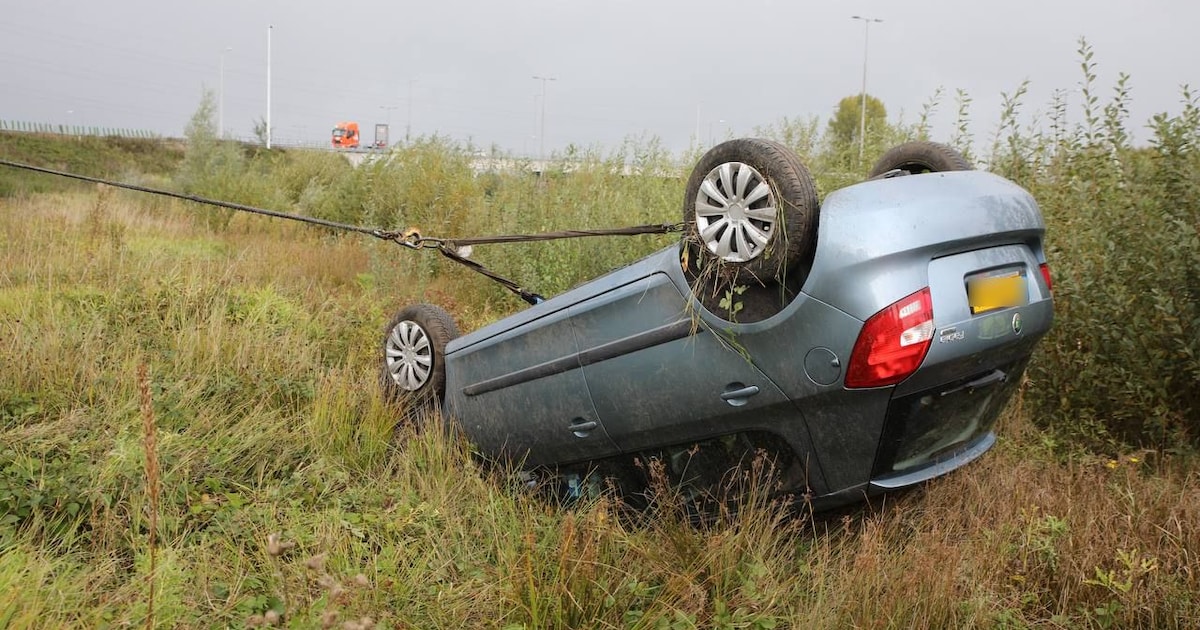 Auto belandt op de kop naast snelweg A1 in Apeldoorn