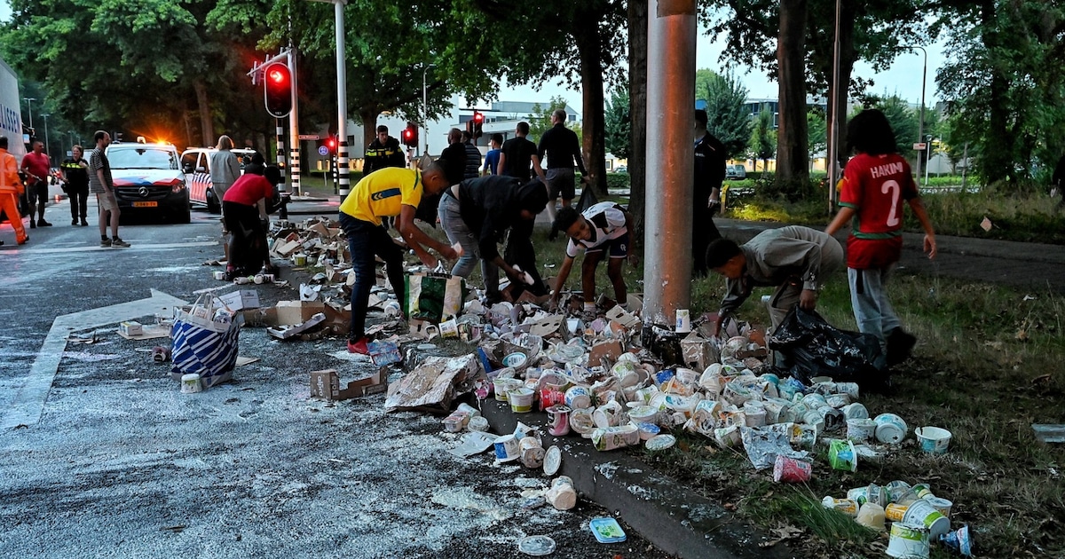 Smurrie op de weg na ongeluk met vrachtwagen vol yoghurt in Tilburg, omstanders laden hun tassen vol.