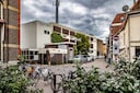 Naast het oude postkantoor, dat is omgebouwd tot appartementencomplex, staat een groot gebouw met een telecommast in het midden. Wat gebeurt daar binnen?