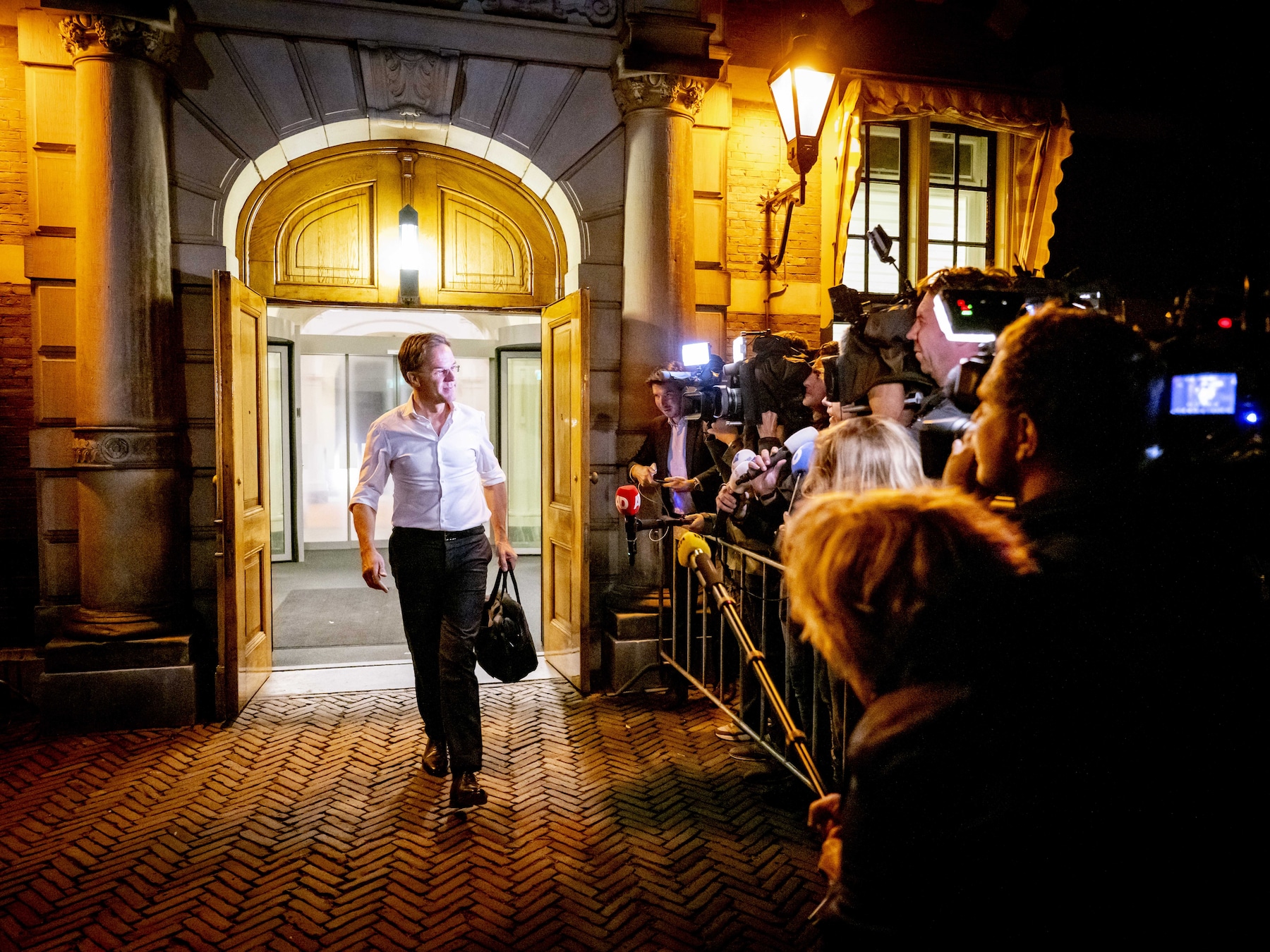 Premier Mark Rutte vertrekt bij Algemene Zaken na een overleg over de asielaanpak. Nieuwe verkiezingen dreigen als het kabinet geen akkoord bereikt over strengere asielregels.