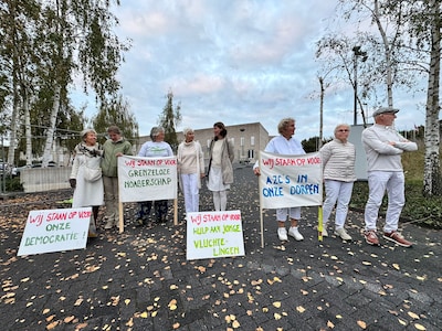 Actievoerders in het wit laten zich zien bij gemeentehuis: juist vóór komst van jonge asielzoekers