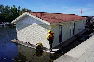 Woonboot dreigt te zinken in Zwartsluis, brandweer pompt water weg
