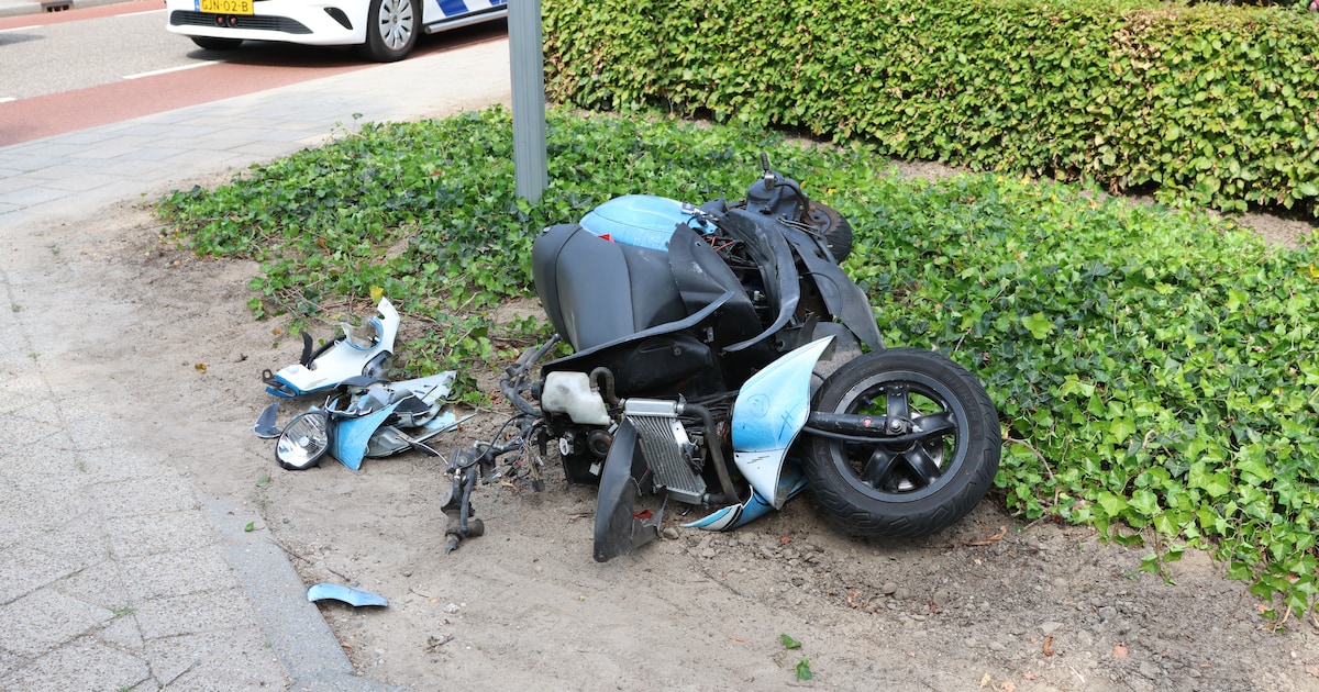 Berm bezaaid met brokstukken van scooter na aanrijding met trekker.