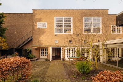 Wonen in een gymzaal in Betondorp? Deze voormalige school staat nu te koop (en nee, je hoeft geen re