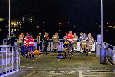 Hulpdiensten zoeken naar drenkeling in de IJ bij het Java-eiland in Amsterdam