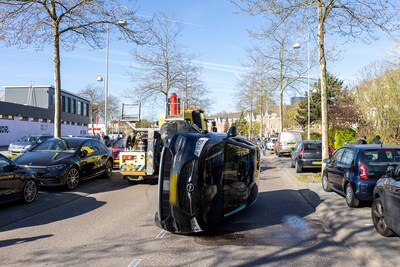 Auto op zijn kant op de Meeuwenlaan in Amsterdam
