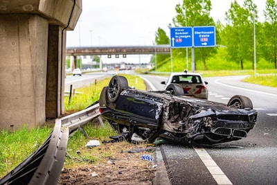 Man (42) uit Zwolle gewond nadat auto van viaduct stort en op de kop op snelweg belandt