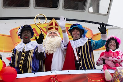 Sinterklaas komt met zwarte- en roetveeg Pieten aan op Urk, jongen aangehouden met een mes