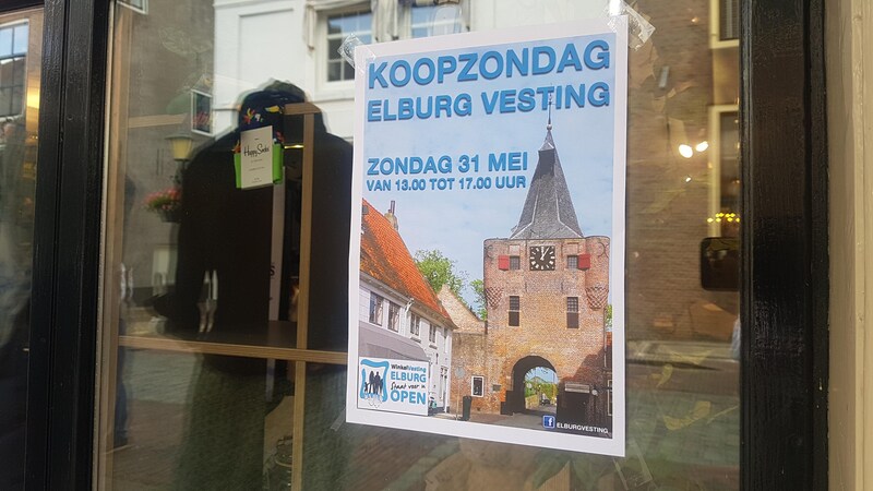De raamposter waarop de koopzondag aangekondigd wordt.