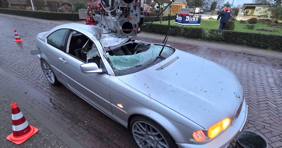 Bouwkraan plet dak van auto na ongeluk: bestuurder wonderwel niet gewond