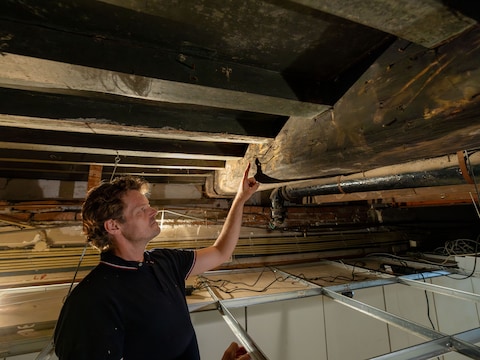 Bouwhistoricus Geert Jan van der Schee bij een van de balkschilderingen.