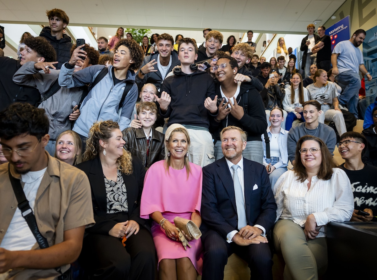 Koning Willem-Alexander en koningin Máxima gaan op de foto met leerlingen tijdens een bezoek aan MBO College Poort. 