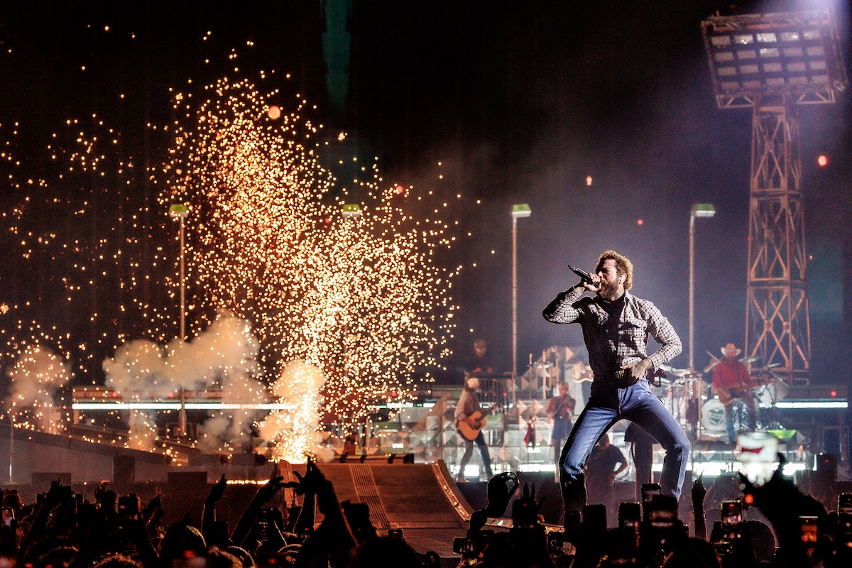 Post Malone treedt op in het GelreDome met vuurwerk op de achtergrond.