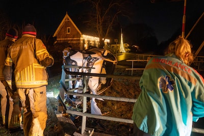 Auto op z’n kant in Schalkhaar, net niet in het water