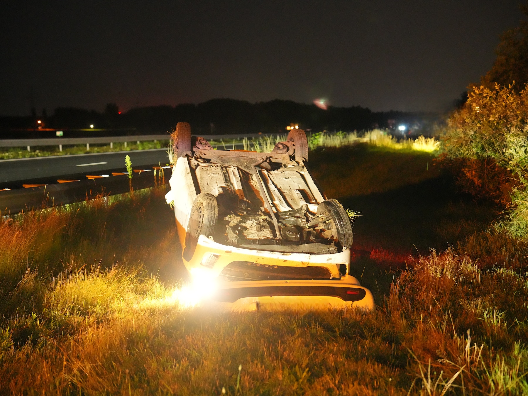 Auto eindigt op zijn kop naast snelweg bij Meppel