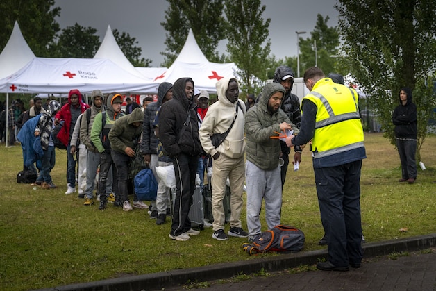 Asylum seekers are ready to board the bus that will take them to an overnight stay.