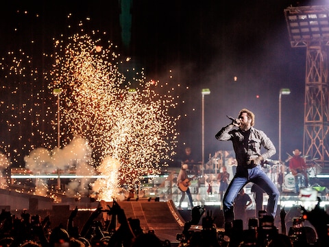 Post Malone treedt op in het GelreDome met vuurwerk op de achtergrond.
