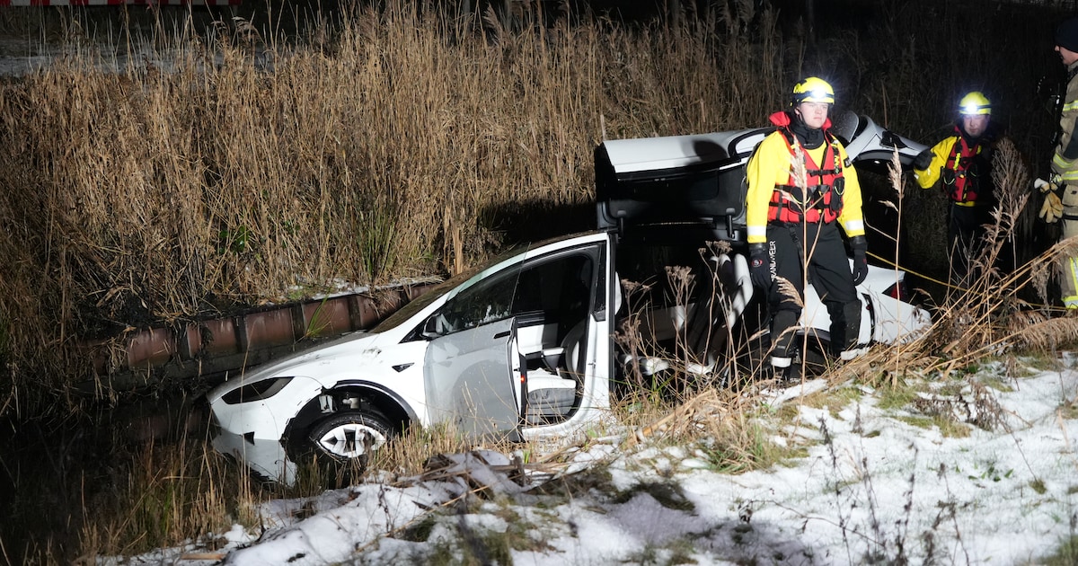 Elektrische auto schiet over kruising en belandt in het water in Weesp